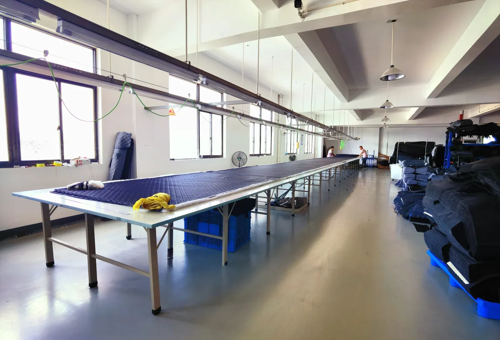 Long worktables and textile materials in a factory work area
